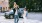 toddler sits on her father's shoulders as her parents walk through a city crosswalk